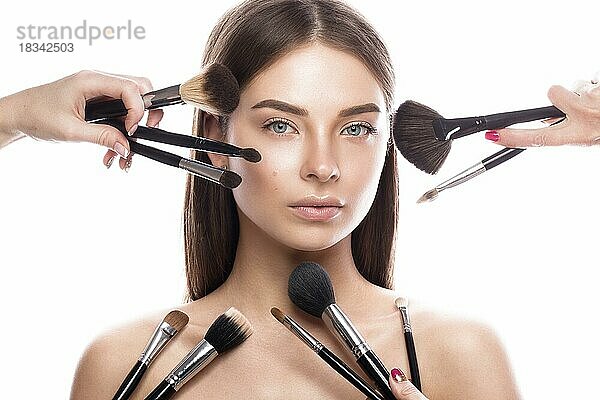 Schönes junges Mädchen mit einem leichten natürlichen Make-up  Pinsel für Kosmetik und perfekte Haut. Schönheit Gesicht. Bild im Studio auf einem weißen Hintergrund genommen