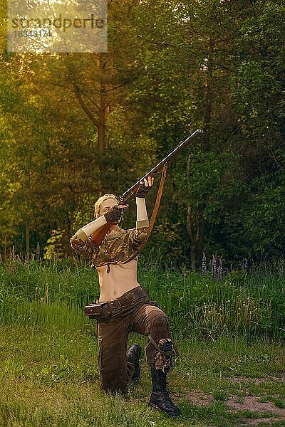 Attraktives Jägermädchen schießt mit doppelläufigem Gewehr