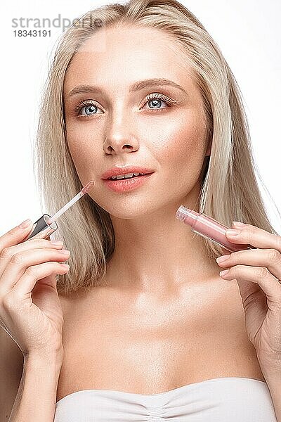 Schönes junges Mädchen mit einem leichten natürlichen Make-up  Lippenstift und nackter Maniküre. Schönes Gesicht. Bild im Studio auf einem weißen Hintergrund genommen