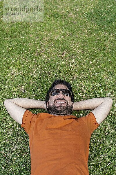 Ansicht von oben Porträt der lateinischen Mann liegt glücklich auf dem Gras