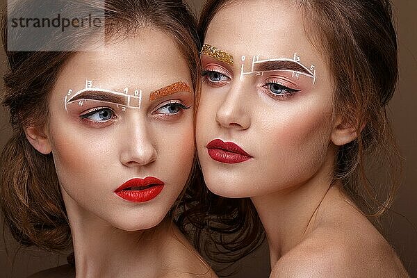 Zwei Mädchen sind Zwillingsschwestern mit einem ungewöhnlichen Augenbrauen-Make-up. Schönes Gesicht. Foto im Studio aufgenommen