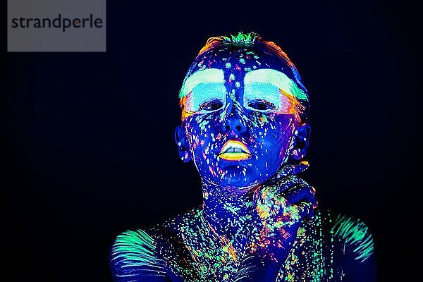 Porträt eines schönen Mädchens mit ultravioletter Farbe im Gesicht. Mädchen mit Neon-Make-up in Farbe Licht