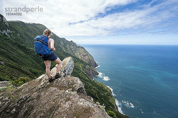 Wanderin am Grat des Pico do Alto  Ausblick auf Steilküste  Küstenlandschaft und Meer  Madeira  Portugal  Europa