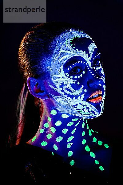 Porträt eines schönen Mädchens mit ultravioletter Farbe im Gesicht. Mädchen mit Neon-Make-up in Farbe Licht