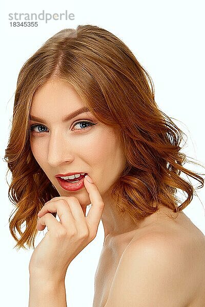 Schöne junge Frau mit blauen Augen  die ihre Lippen berühren. Schönheit Porträt  frische Haut. Natürliches Make-up