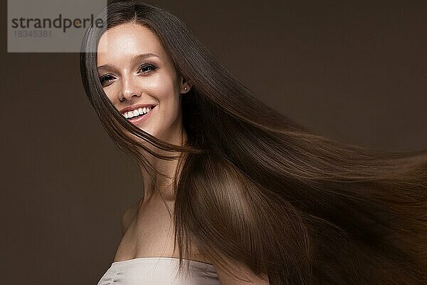 Schönes brünettes Mädchen in Bewegung mit einem perfekt glatten Haar  und klassisches Make-up. Schönes Gesicht. Bild im Studio aufgenommen