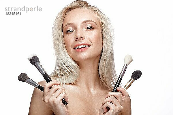 Schönes junges Mädchen mit einem leichten natürlichen Make-up  Pinsel für Kosmetik und nackte Maniküre. Schönheit Gesicht. Bild im Studio auf einem weißen Hintergrund genommen