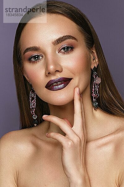 Schönes Mädchen mit hellen modischen Make-up und langen dicken Haaren. Schönes Gesicht. Foto im Studio aufgenommen