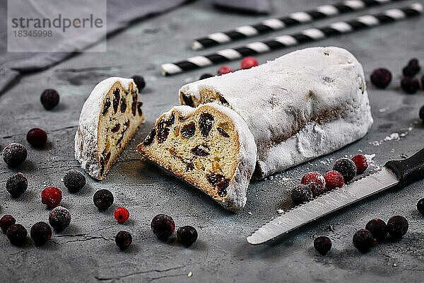 Ein Stück der traditionellen deutschen Weihnachtssüßspeise Stollen oder Christstollen  ein Früchtebrot mit Nüssen  Gewürzen und getrockneten oder kandierten Früchten  bestreut mit Puderzucker