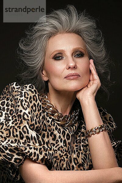 Porträt einer schönen älteren Frau in einer Leopardenbluse mit klassischem Make-up und grauem Haar
