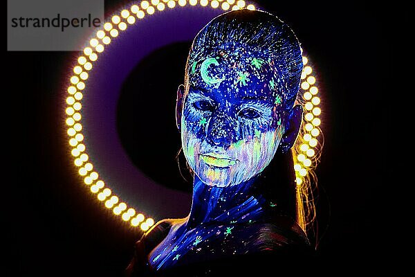 Porträt eines schönen Mädchens mit ultravioletter Farbe im Gesicht. Mädchen mit Neon-Make-up in Farbe Licht