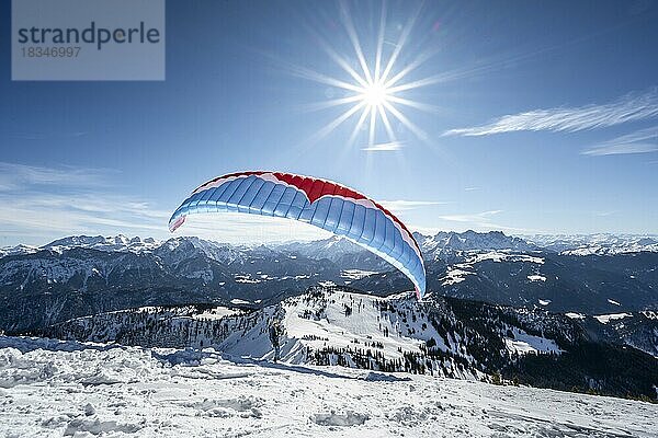 Paraglider beim Start im Winter  Gipfel des Sonntagshorn  Bergpanorama  Sonnenstern  Chiemgauer Alpen  Bayern  Deutschland  Europa