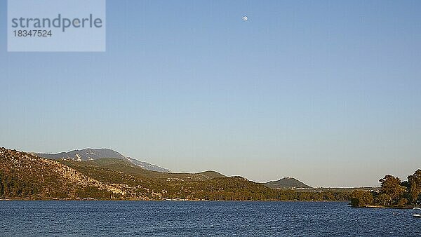 Bucht von Argostoli  Vollmond klein  bewaldete Hügel  Blauer wolkenloser Himmel  Argostoli  Insel Kefalonia  Ionische Inseln  Griechenland  Europa