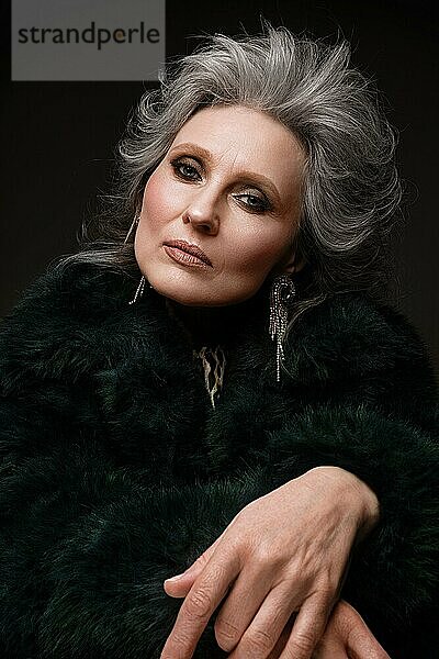 Porträt einer schönen älteren Frau in einer Leopardenbluse und einem Pelzmantel mit klassischem Make-up und grauem Haar