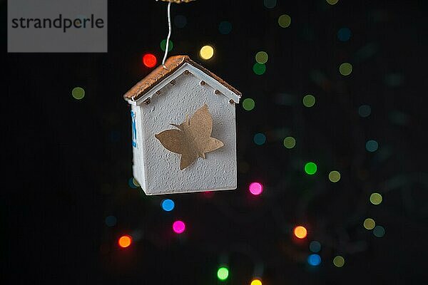 Papier Schmetterling auf einem Modell Haus auf einem Bokeh Licht