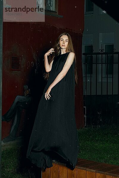 Ruhig Mode-Modell posiert im Freien in langen Designer Kleid in der Nacht