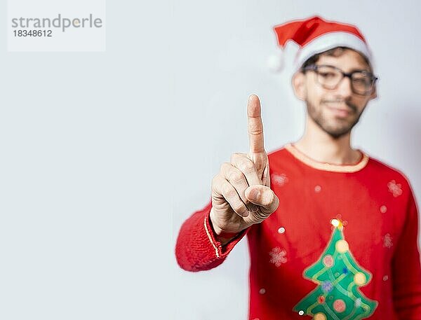 Mann in Weihnachtsmütze zählt mit dem Finger die Zahl eins. Mann im Weihnachtskostüm zählt Nummer eins mit dem Finger. Konzept der Mann im Weihnachtskostüm Zählen der Nummer eins isoliert