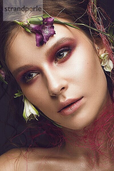 Schönes Mädchen mit Kunst Make-up und Blumen. Schönheit Gesicht. Fotos im Studio geschossen