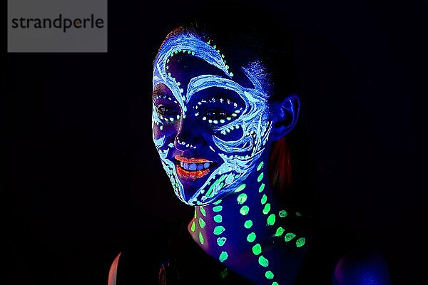 Porträt eines schönen Mädchens mit ultravioletter Farbe im Gesicht. Mädchen mit Neon-Make-up in Farbe Licht