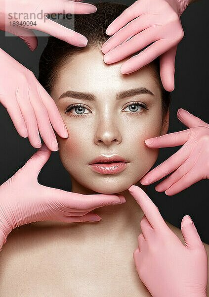 Schönes junges Mädchen mit natürlichen nackt Make-up mit kosmetischen Werkzeugen in den Händen. Schönes Gesicht. Foto im Studio aufgenommen