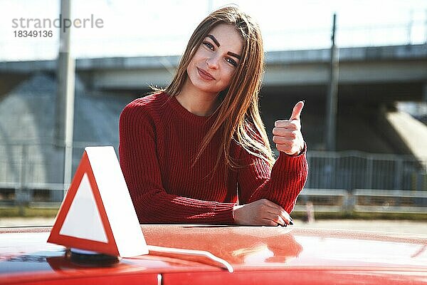Junge schöne glückliche Frau posiert in der Nähe von Training Auto