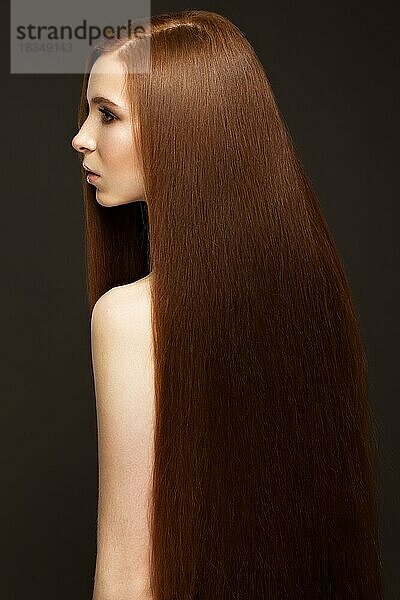 Schönes Redheadgirl mit perfekt glattem Haar und klassischem Make-up. Schönes Gesicht. Bild im Studio auf einem weißen Hintergrund aufgenommen