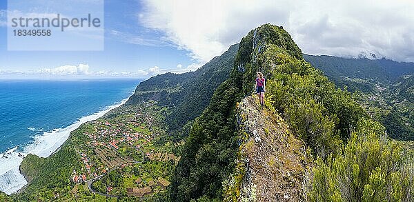 Wanderin am Grat des Pico do Alto  Blick über Küstenlandschaft  Ort Arco de Sao Jorge  Madeira  Portugal  Europa