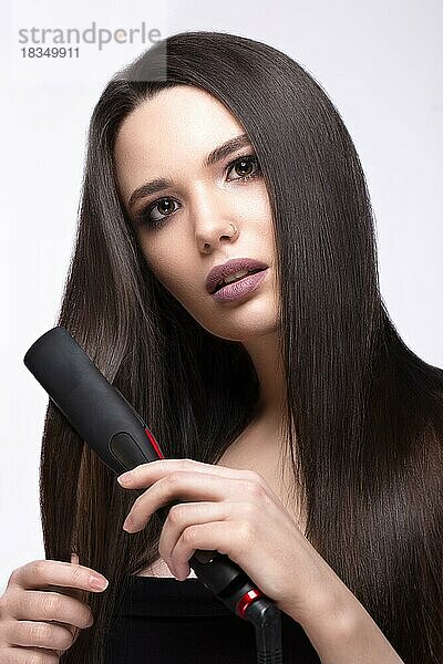 Schöne brünette Mädchen mit einem perfekt glatten Haar  Locken und klassischen Make-up. Schönheit Gesicht. Bild im Studio auf einem weißen Hintergrund genommen