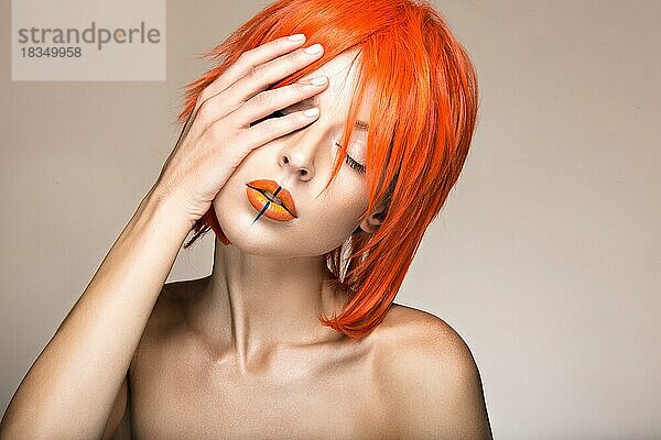 Schönes Mädchen in einem orangefarbenen Perücke Cosplay-Stil mit hellen kreativen Lippen. Kunst Schönheit Bild. Porträtaufnahme im Studio