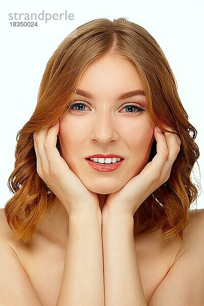 Schöne junge Frau mit blauen Augen und roten Lippen  die ihr Kinn berühren. Schönheit Porträt  frische Haut. Natürliches Make-up