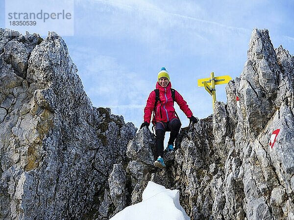 Bergsteigerin klettert über eine felsige Scharte  Hoher Göll  Berchtesgadener Alpen  Nationalpark Berchtesgaden  Schönau am Königssee  Berchtesgadener Land  Oberbayern  Bayern  Deutschland  Europa