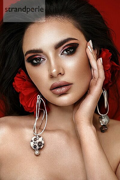Schöne Frau mit hellen modischen Make-up und ungewöhnliche rote Accessoires. Schönes Gesicht. Foto im Studio aufgenommen