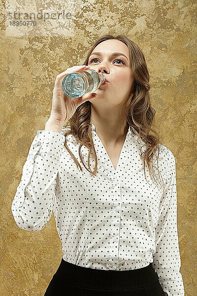 Porträt eines attraktiven Mädchens  das reines Wasser aus einer Flasche trinkt