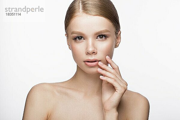 Schönes junges Mädchen mit einem leichten natürlichen Make-up und französischer Maniküre. Schönes Gesicht. Bild im Studio auf einem weißen Hintergrund aufgenommen