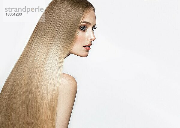 Schönes blondes Mädchen mit einem perfekt glatten Haar und klassischem Make-up. Schönes Gesicht. Bild im Studio aufgenommen