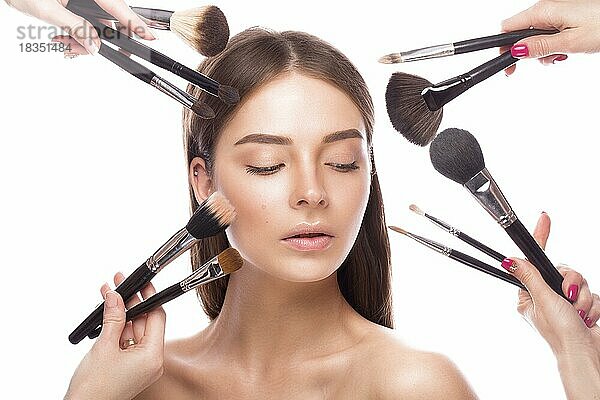 Schönes junges Mädchen mit einem leichten natürlichen Make-up  Pinsel für Kosmetik und perfekte Haut. Schönheit Gesicht. Bild im Studio auf einem weißen Hintergrund genommen