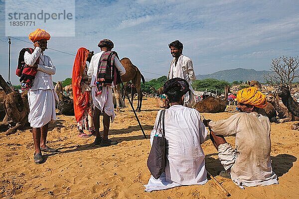 Indische Männer und Kamele auf dem Pushkar-Kamelmarkt (Pushkar Mela)  der jährlichen Kamel- und Viehmesse  einer der größten Kamelmessen der Welt und Touristenattraktion  Pushkar  Indien  Asien
