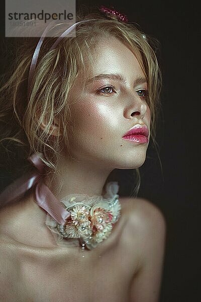 Schöne blonde Mode Mädchen mit Blumen auf den Hals und in den Haaren  nass Nude Make-up. Schönes Gesicht. Fotos im Studio geschossen