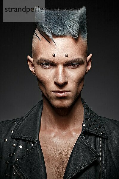 Junger Mann mit blauem Haar und kreativem Make-up und Haar. Foto im Studio aufgenommen