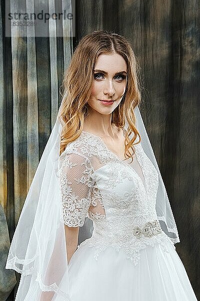 Porträt der hübschen Braut im Hochzeitskleid mit Schleier im Haar