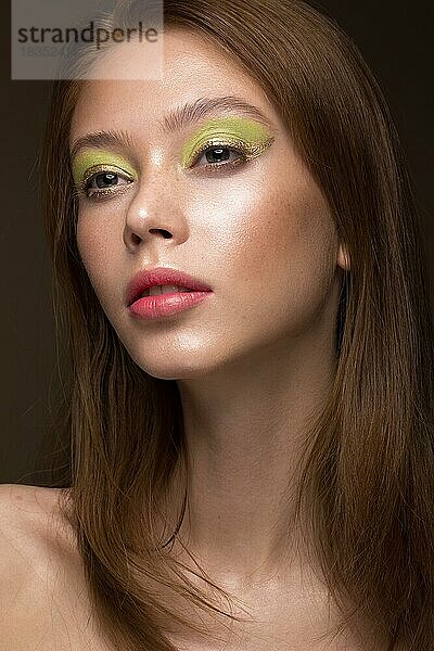 Schönes rothaariges Mädchen mit kreativem grünen Make-up. Schönes Gesicht. Fotos im Studio aufgenommen