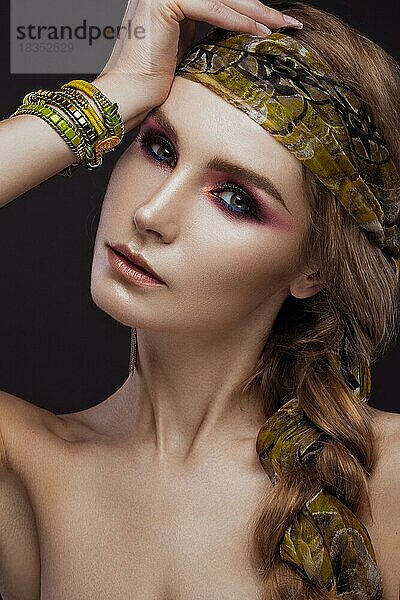 Schöne Mode Mädchen in einem Schal und Armbänder Boho-Stil. Schönheit Gesicht  helle trendy Make-up. Bild im Studio aufgenommen