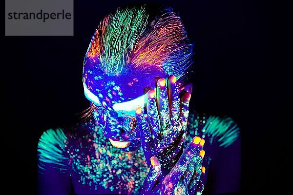 Porträt eines schönen Mädchens mit ultravioletter Farbe im Gesicht. Mädchen mit Neon-Make-up in Farbe Licht