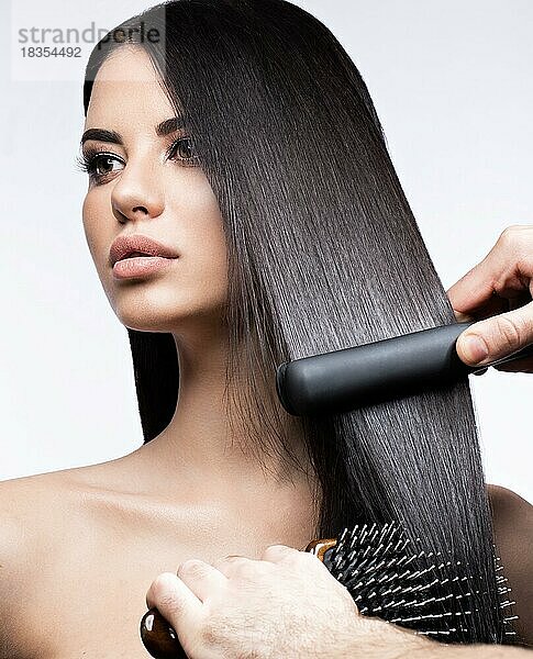 Schöne brünette Mädchen mit einem perfekt glatten Haar  Locken und klassischen Make-up. Schönheit Gesicht. Bild im Studio auf einem weißen Hintergrund genommen