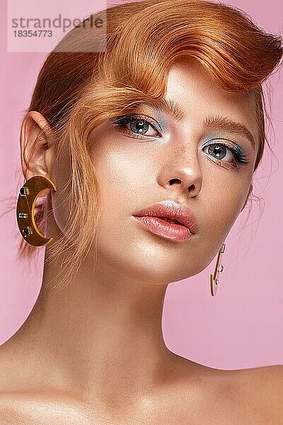 Schönes Mädchen mit ungewöhnlichen Accessoires und Make-up auf einem hellen Hintergrund. Schönes Gesicht. Foto im Studio aufgenommen