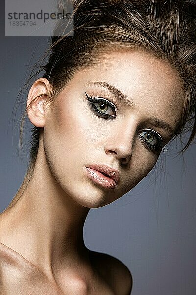 Schönes Mädchen mit langen Wimpern und perfekter Haut. Bild im Studio auf einem grauen Hintergrund genommen. Schönheit Gesicht