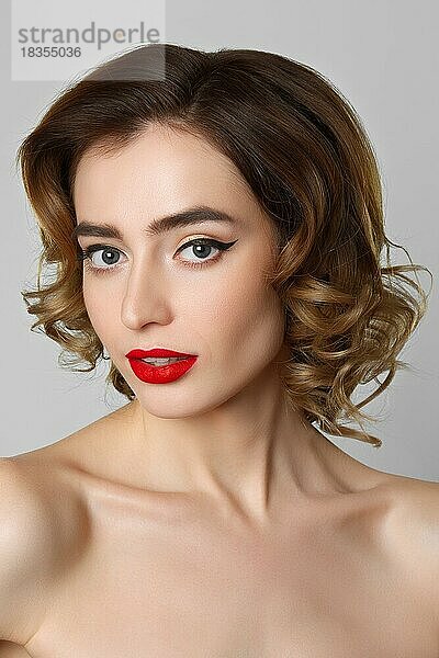 Beauty-Porträt von hübschen Mädchen mit lockigem Haar  Katzenaugen-Make-up  rote Lippen. Schönheit  Kosmetik-Konzept. Gesundheitswesen