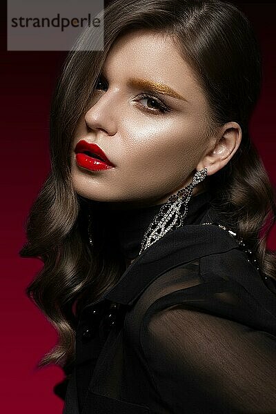 Schönes Mädchen mit roten Lippen und goldenen Augenbrauen  Locken im Hollywood-Stil. Schönes Gesicht. Foto im Studio aufgenommen