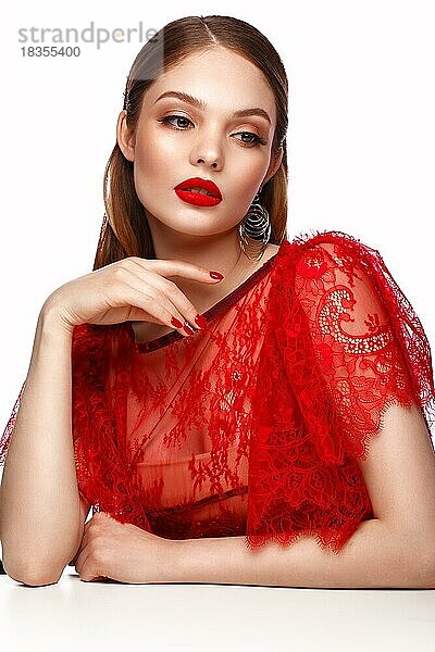 Schönes Mädchen in rotem Kleid mit klassischem Make-up und roter Maniküre. Schönes Gesicht. Foto im Studio aufgenommen