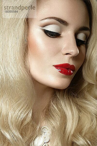 Schöne blonde Frau mit Abend-Make-up und roten Lippen. Bild im Studio auf einem schwarzen Hintergrund aufgenommen